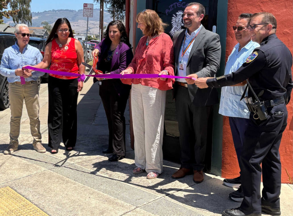 Santa Cruz County District Attorney Jeff Rosell, left, joins Aztecas Youth Soccer Academy founder Gina Castañeda, Chief Probation Officer Sandra Mendez, 1440 Multiversity co-creator Joanie Kriens, Santa Cruz County Superintendent of Schools Faris Sabbah, Ramon Gomez from Santa Cruz County Supervisor Felipe Hernandez’s office and Watsonville Police Chief Brian Shab in a ribbon-cutting ceremony at Aztecas new clubhouse.