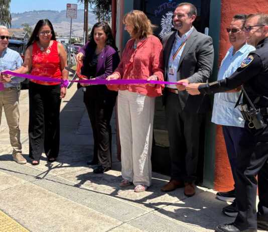 Santa Cruz County District Attorney Jeff Rosell, left, joins Aztecas Youth Soccer Academy founder Gina Castañeda, Chief Probation Officer Sandra Mendez, 1440 Multiversity co-creator Joanie Kriens, Santa Cruz County Superintendent of Schools Faris Sabbah, Ramon Gomez from Santa Cruz County Supervisor Felipe Hernandez’s office and Watsonville Police Chief Brian Shab in a ribbon-cutting ceremony at Aztecas new clubhouse.