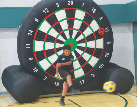 During National Night Out the boy tests his soccer skills with the aid of a giant target at the Gene Hoularis and Waldo Rodriguez Youth Center in Watsonville.