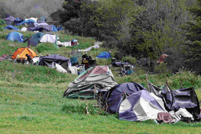 In 2024, a string of tents and makeshift shelters lined the Pajaro River levee in Watsonville. (Tarmo Hannula/Pajaronian file)