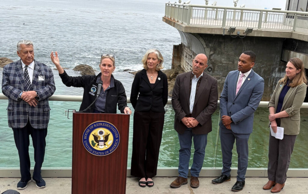 Ted Balestreri, CEO and Chairman of the Cannery Row Company, left, joins Monterey County Supervisor Supervisor Kate Daniels, at podium, along with Monterey Bay Aquarium CEO Jenny Gray, Rep. Jimmy Panetta, Monterey Mayor Tyller Williamson and Save Our Shores Executive Director Katie Thompson. (Todd Guild/The Pajaronian)