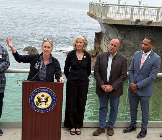 Ted Balestreri, CEO and Chairman of the Cannery Row Company, left, joins Monterey County Supervisor Supervisor Kate Daniels, at podium, along with Monterey Bay Aquarium CEO Jenny Gray, Rep. Jimmy Panetta, Monterey Mayor Tyller Williamson and Save Our Shores Executive Director Katie Thompson. (Todd Guild/The Pajaronian)