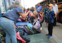 Stuff the Bus volunteers pack 2,500 backpacks for students