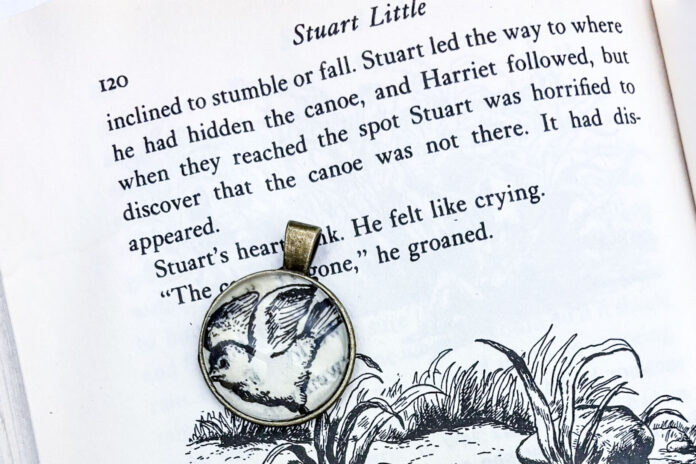 A necklace pendant shown with the book that it was made out of.